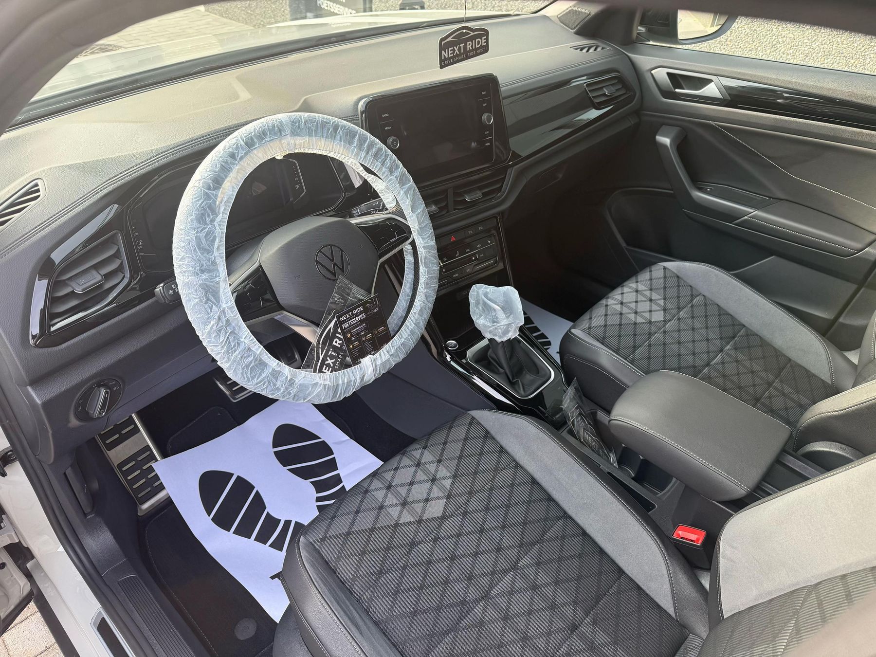 Het interieur van een Volkswagen T-Roc na de poetsbeurt, met beschermhoezen nog op het stuur en de stoel